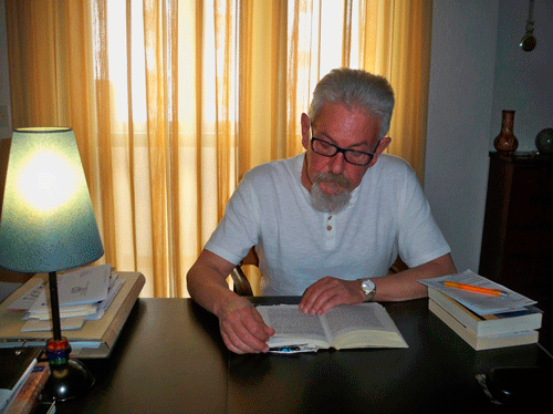 Alfredo Cimiano en su despacho leyendo un libro